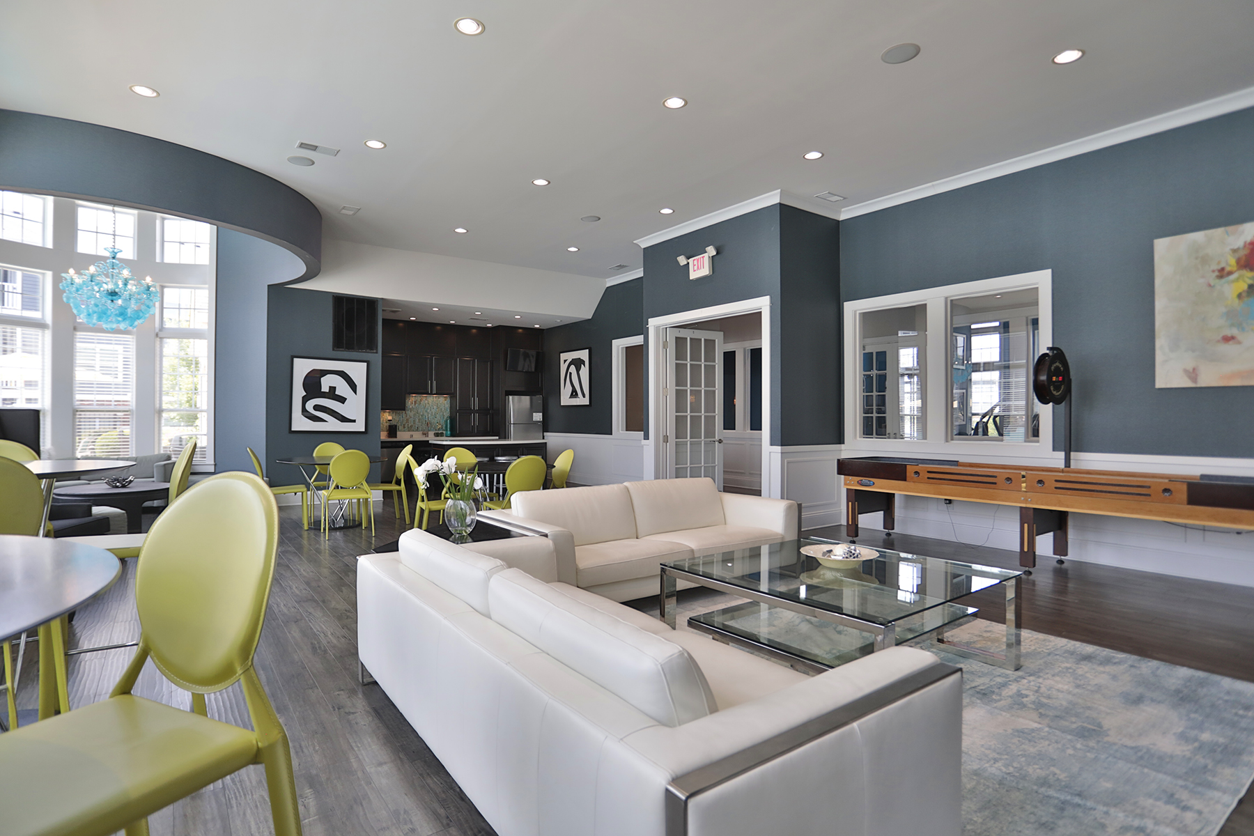 Rentable multipurpose room at Kendal on Taylorsville designed for gatherings and events, featuring comfortable seating, a shuffleboard table, and a full kitchen for entertaining.