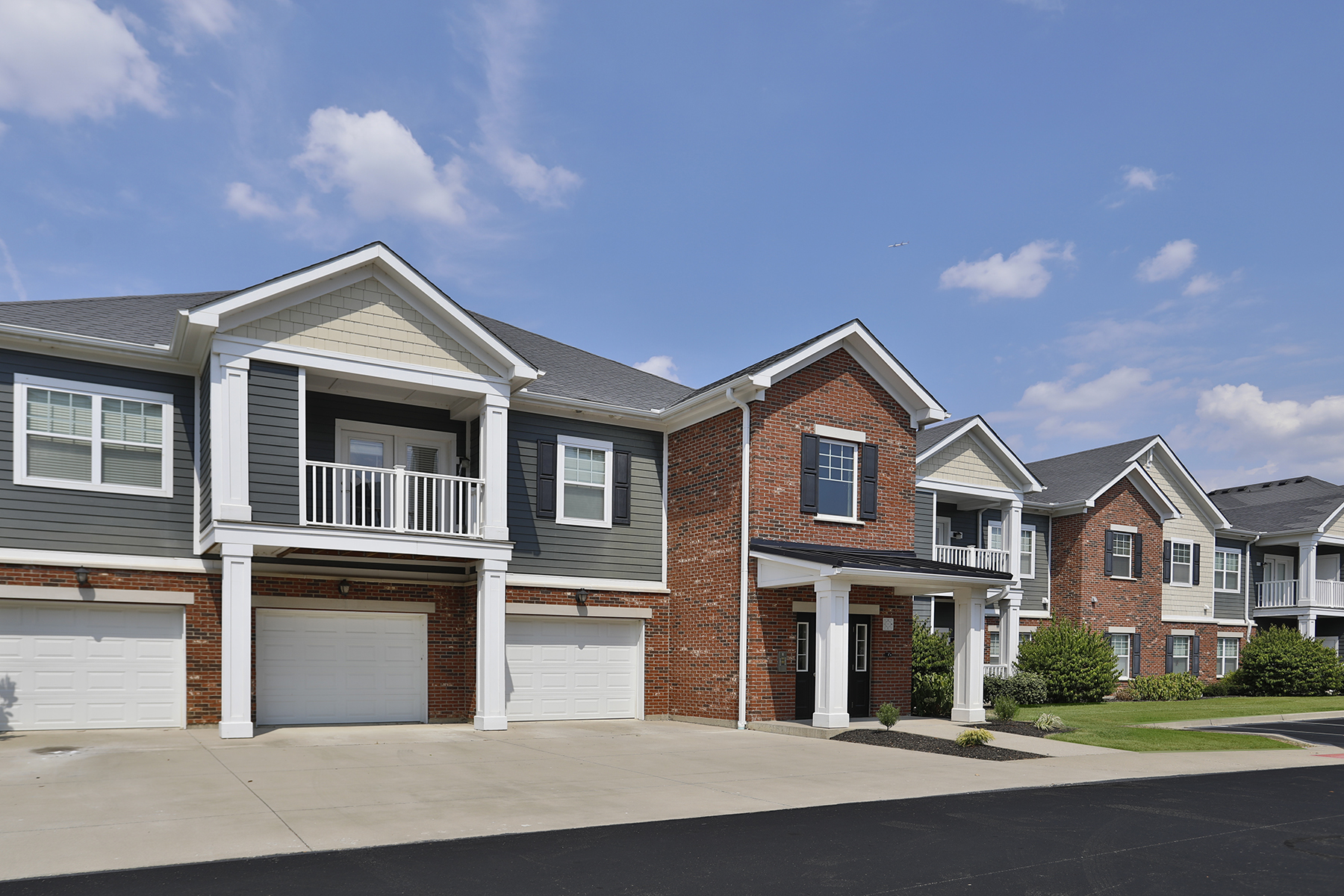 Exterior view of Kendal on Taylorsville featuring modern two-story residential buildings with attached garages and stylish architecture surrounded by landscaped grounds.
