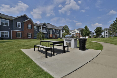 Courtyard grilling area at Kendal on Taylorsville with built-in grills, outdoor seating, and landscaped surroundings ideal for dining and gathering with neighbors.