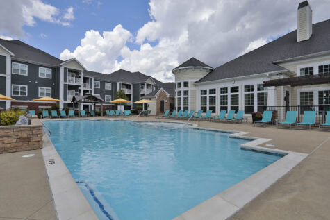 Resort-style swimming pool at Kendal on Taylorsville featuring in-pool lounge seating, shaded cabanas, and a relaxing atmosphere for residents to unwind.