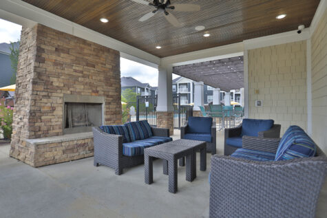 Outdoor social deck at Kendal on Taylorsville offering grilling stations, cozy fireplace seating, and high-top tables perfect for socializing and enjoying the view.