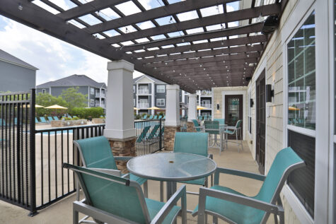 Outdoor social deck at Kendal on Taylorsville offering grilling stations, cozy fireplace seating, and high-top tables perfect for socializing and enjoying the view.