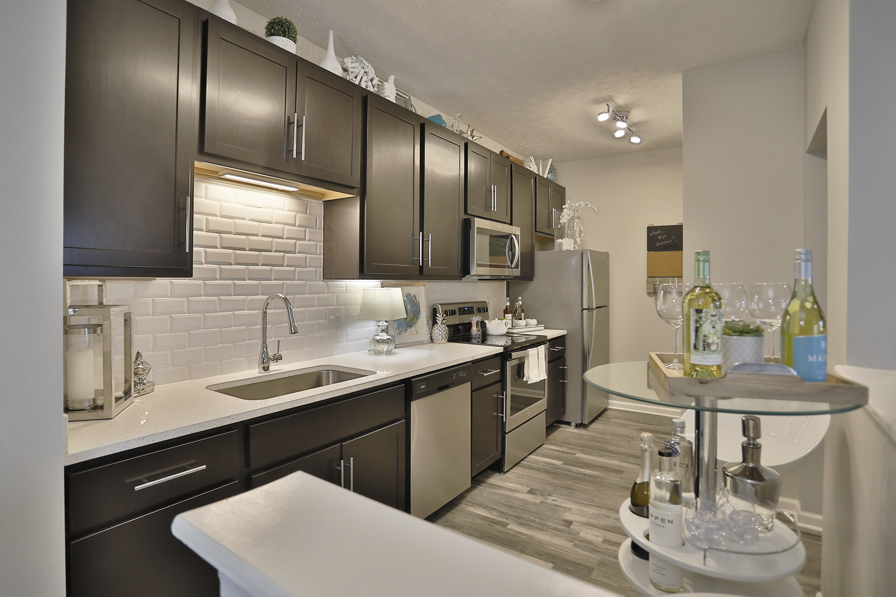 Modern kitchen with white cabinetry, stainless steel appliances, and eat-in kitchen with stylish seating.