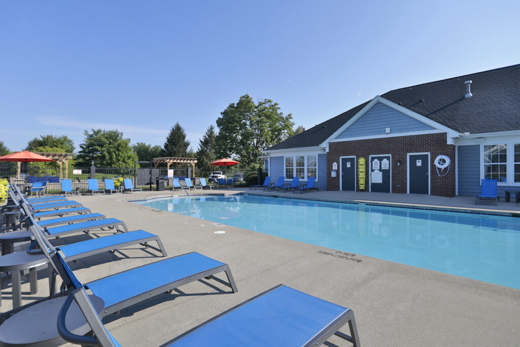 Resort-style swimming pool surrounded by a spacious sundeck with lounge chairs and umbrellas at The Landings at Beckett Ridge.