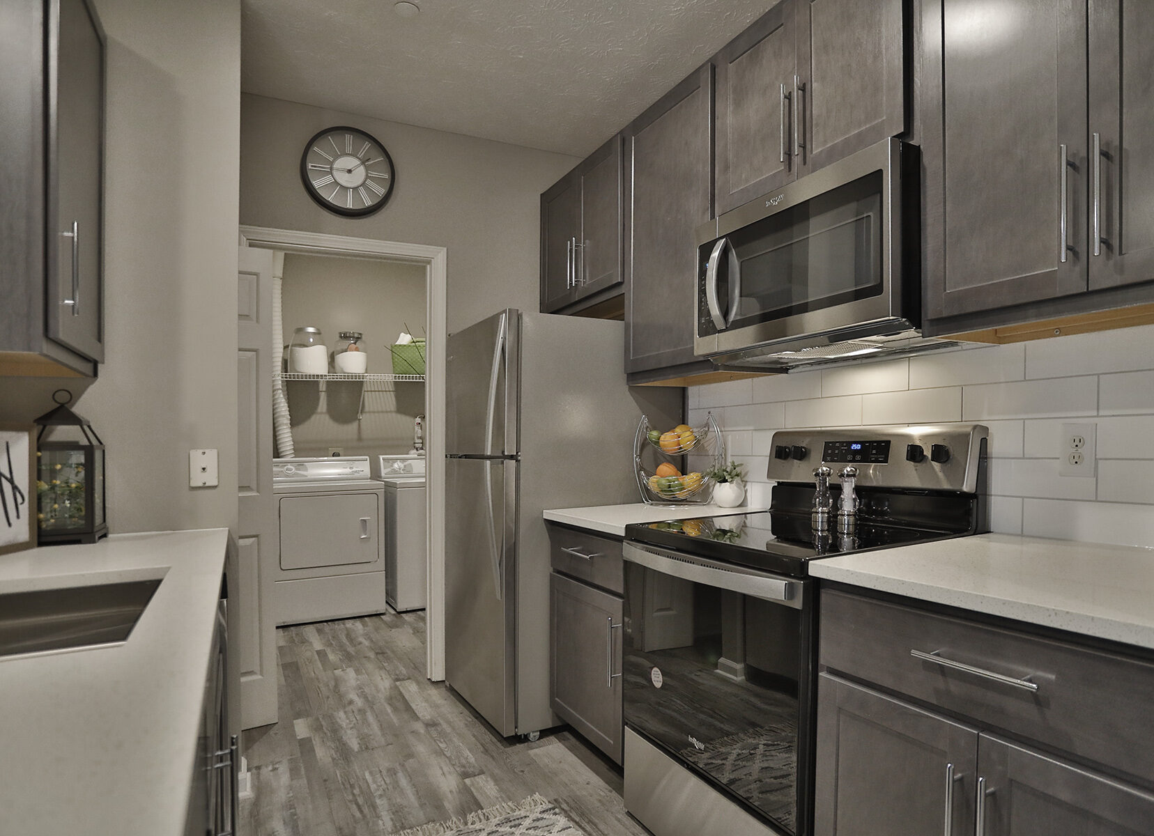 Waterford Place kitchen with stainless steel appliances, custom wood cabinetry and quartz counters.