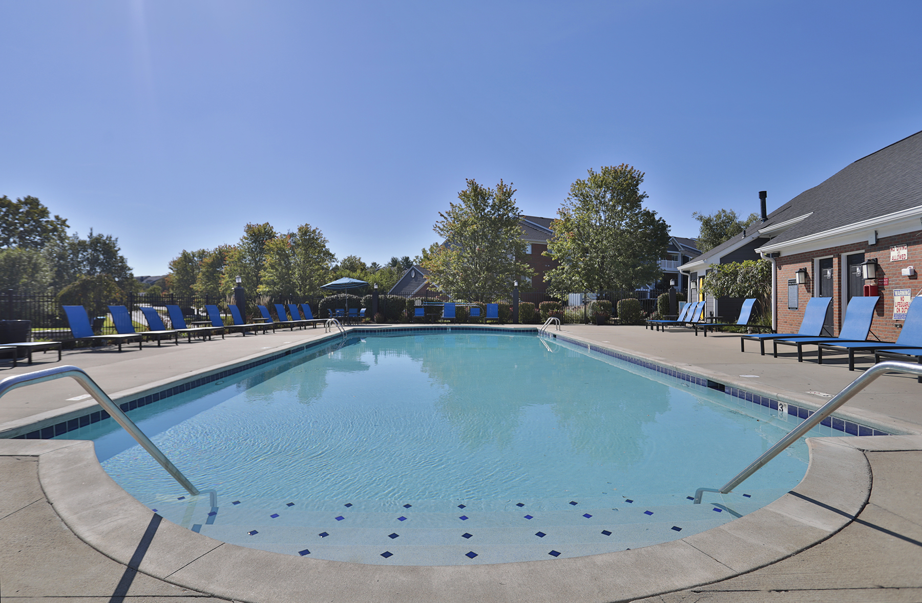 Waterford Place resort style swimming pool surrounded by blue pool-side seating.