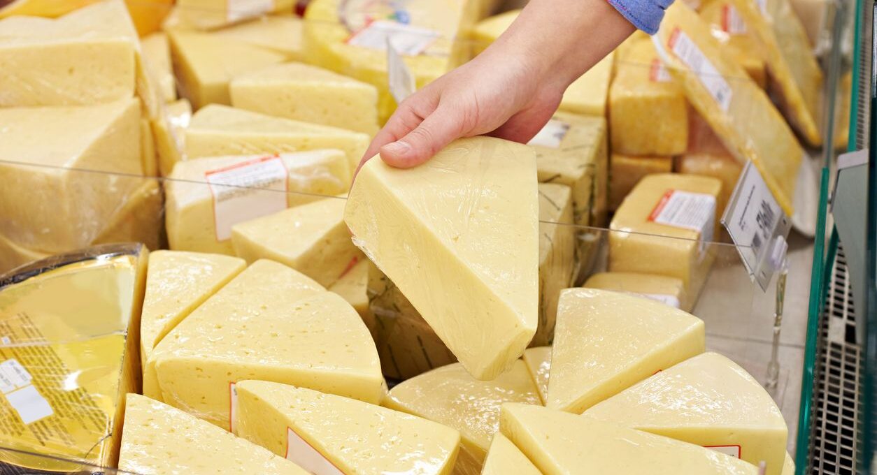 A shopper inspects gourmet cheeses.