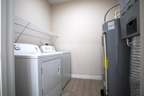 In-home laundry room at Relay 129 with full-size washer and dryer, bright lighting, and functional layout for convenient everyday use.