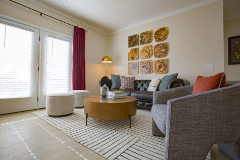 Bright living room at Relay 129 in Liberty Township featuring open-concept layout, large windows, modern finishes, and seamless flow into the kitchen with matte black hardware accents.
