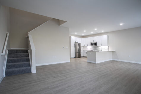 Open-concept living room in 3 bedroom townhome at Relay 129 with large windows, modern finishes, and seamless flow to kitchen and dining area.