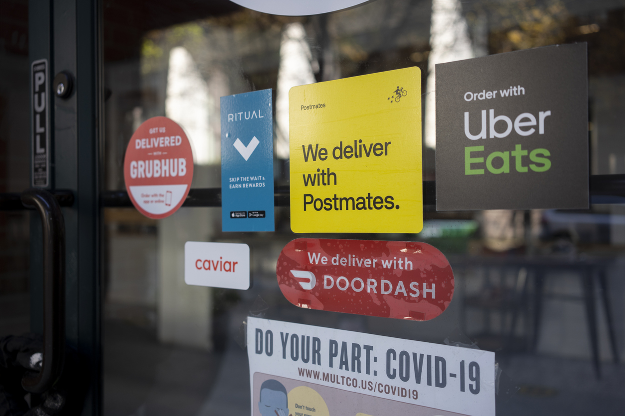 A door covered with various food delivery service stickers