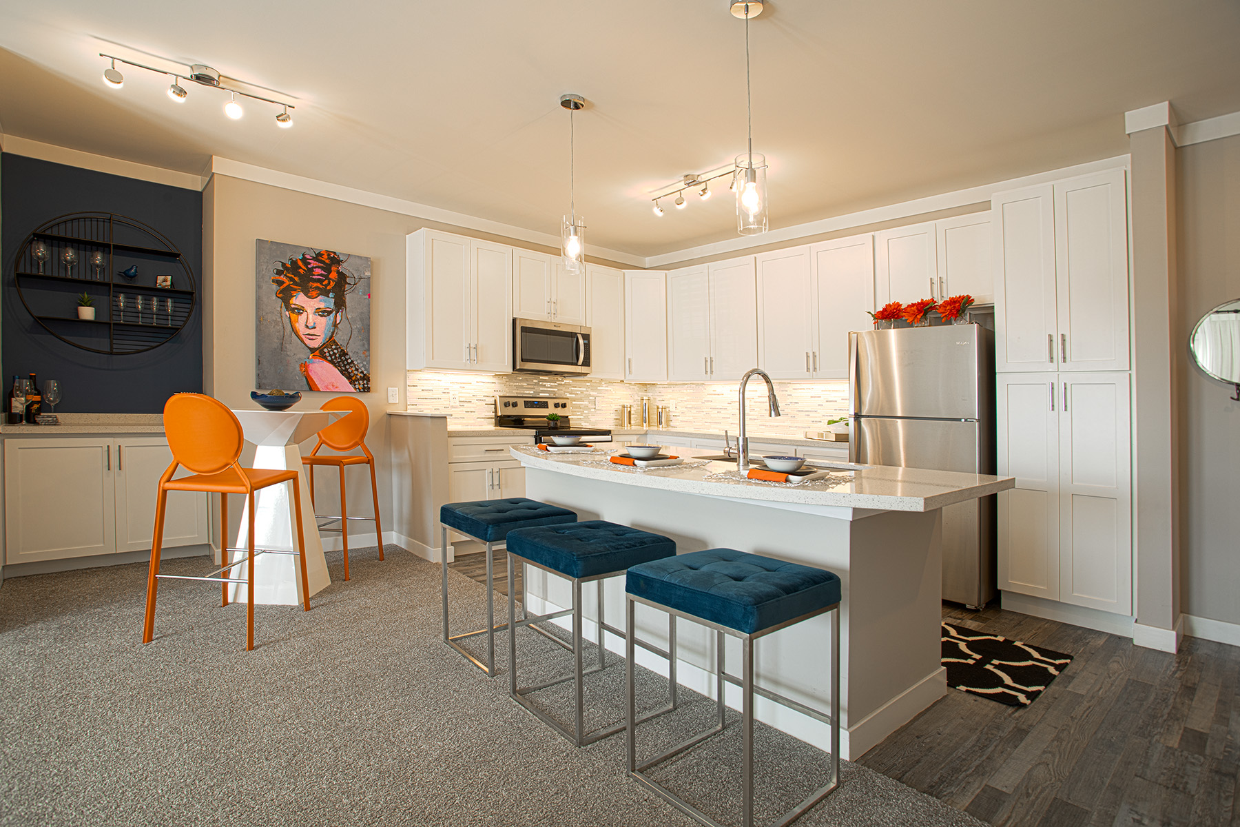Open-concept kitchen at Allure in Centerville, Ohio by Hills Properties featuring white shaker cabinetry, stainless steel appliances, oversized island seating, quartz countertops, and modern pendant lighting.