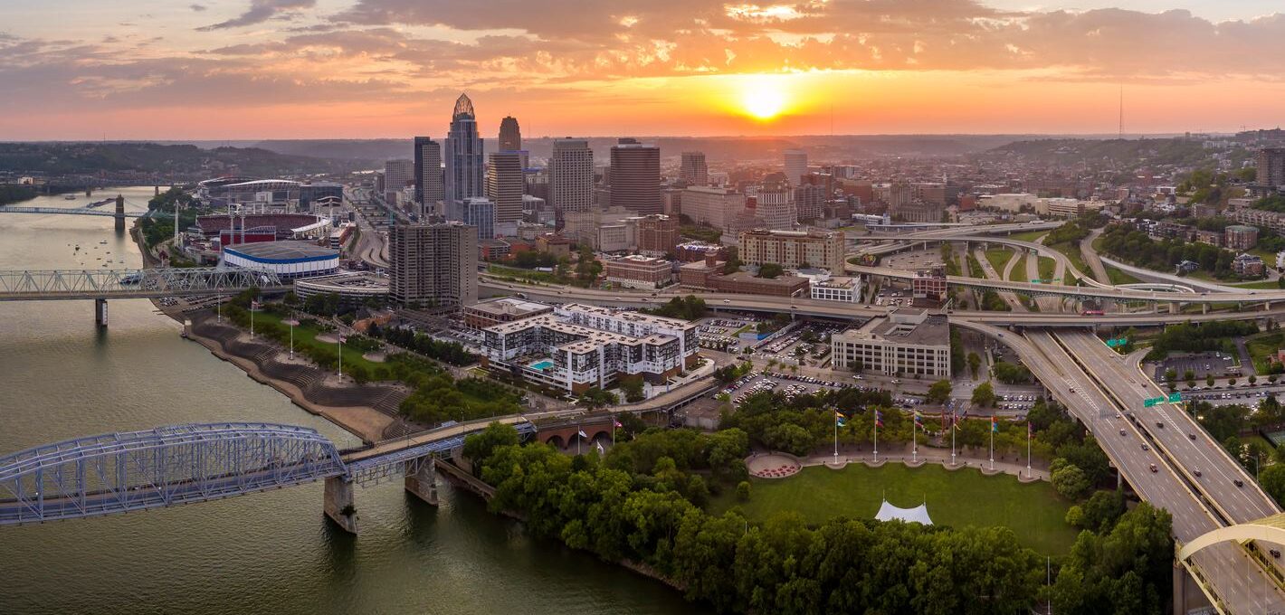 Cincinnati in the state of Ohio, with brightly illuminated high skyscraper buildings in the downtown district. American megapolis with a business financial district at sunset.
