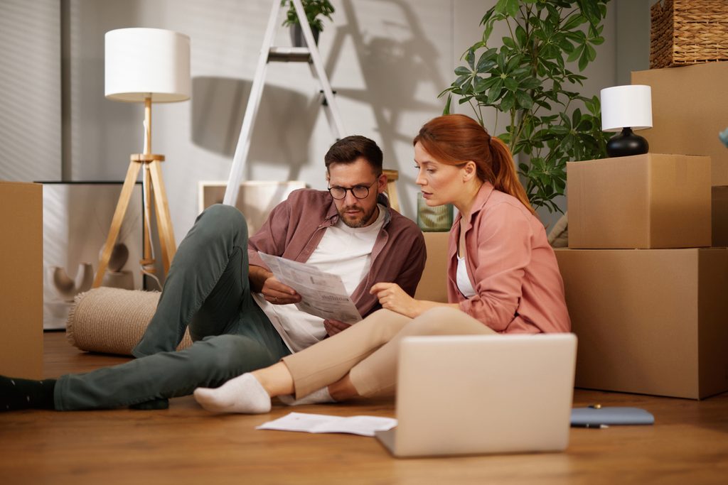 Couple reading instructions while moving into new home.
